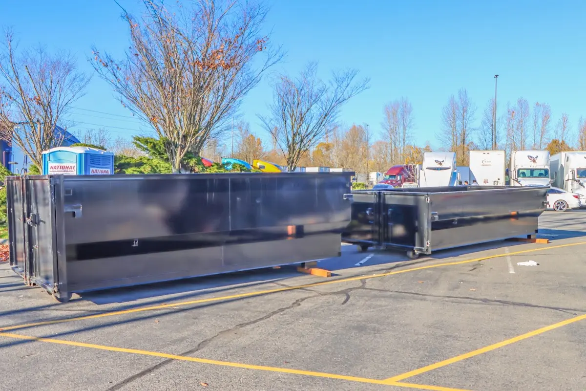 Professional dumpster rental service with roll-off container on residential driveway in East Fallowfield